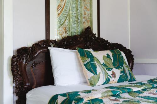 a bed with a wooden headboard and two pillows at Hawaiian Sanctuary Eco Retreat Center in Pahoa