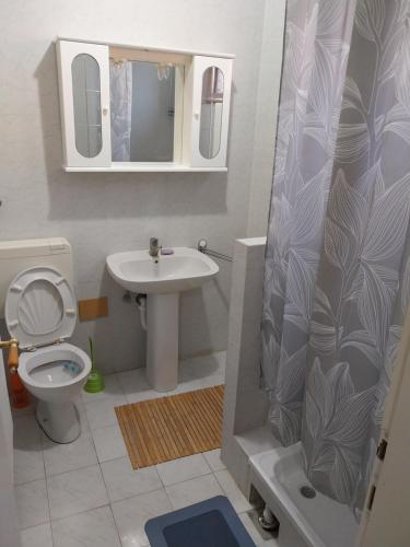 een badkamer met een wastafel, een toilet en een spiegel bij ENJOYMENT House 