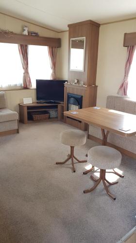 a living room with a wooden table and two chairs at Kingsley vale in Selsey