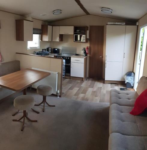 a kitchen and living room with a table and a couch at Kingsley vale in Selsey