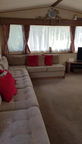 a living room with a couch and some windows at Kingsley vale in Selsey