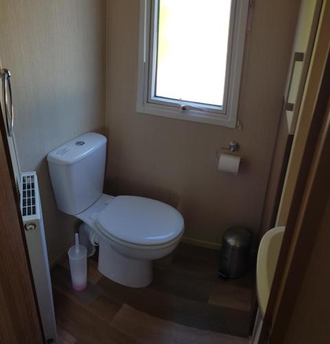 a small bathroom with a toilet and a window at Kingsley vale in Selsey