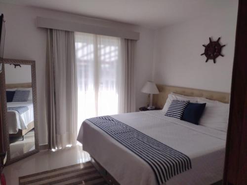 a bedroom with a large bed and a mirror at Pousada Camarote Itaipu in Niterói