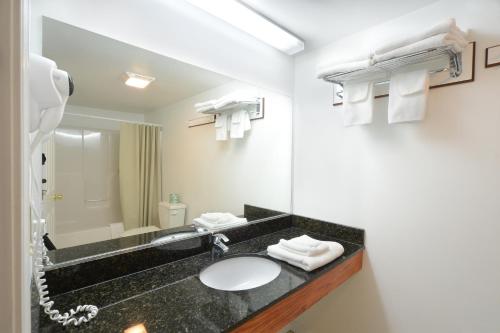 a bathroom with a sink and a mirror at Studio Motel of Lake George in Lake George