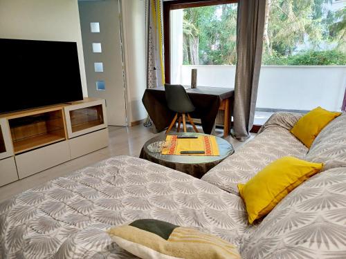 a living room with a couch and a television at Superbe appartement 3p, parking gratuit proche Paris in Châtenay-Malabry