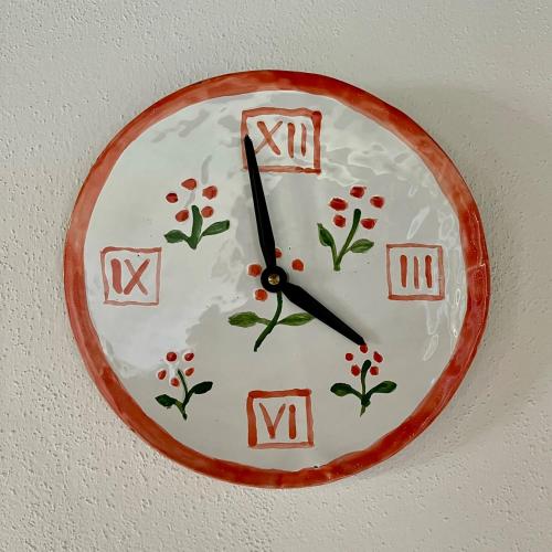 a clock with flowers is hanging on a wall at Kaproun - Studený pramen in Kunžak