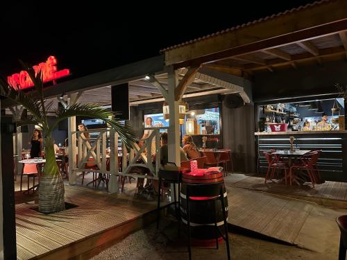 ein Restaurant, in dem Leute an Tischen auf einer Terrasse sitzen in der Unterkunft Villa Matouba in Saint-François