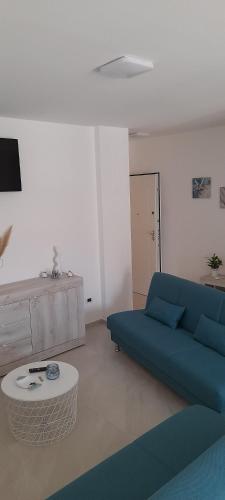 ein Wohnzimmer mit einem blauen Sofa und einem Tisch in der Unterkunft Appartamento garibaldi in San Benedetto del Tronto