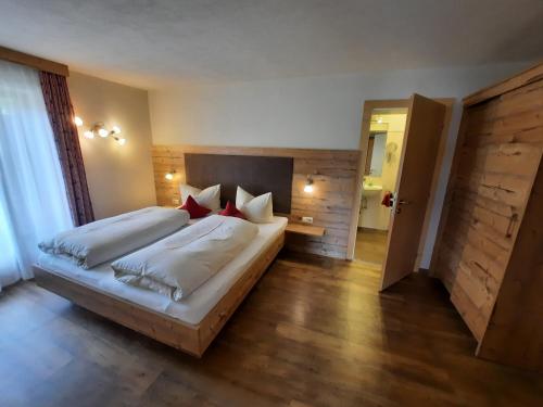 a bedroom with two beds with white sheets and red pillows at Haus am Römerweg in Lermoos