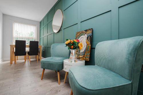 a living room with two chairs and a vase of flowers at Brimmond Homes - nr to Univ, Hospitals, o2 Apollo, PLAB & 7 mins to City Centre - Stylish, Modern & Secure 2 Bed, 2 Bath Apt with Allocated Free Parking in Manchester