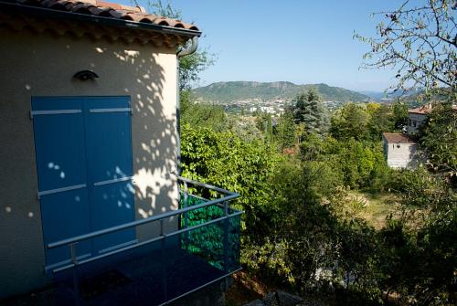 a blue door on the side of a building at Nid douillet - LES FARGETTES - superbe vue - charmante petite maison avec jardin - 2 pièces à Privas in Privas