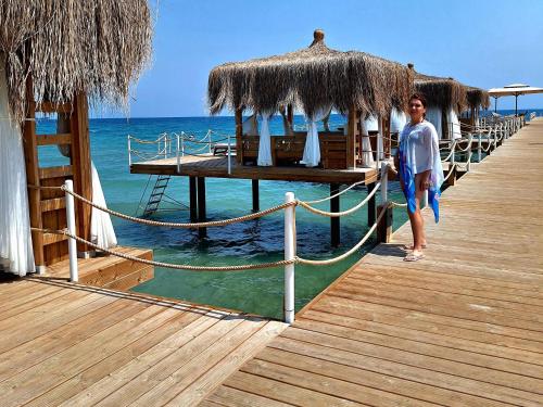 a woman is standing on a pier near the water at Boheme B6 Sunrise Beach in Kalecik