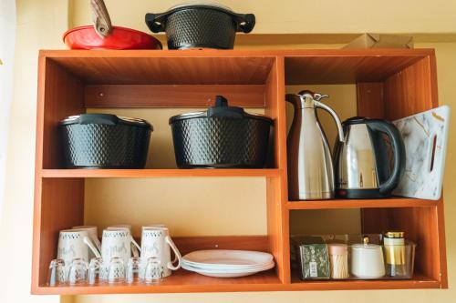 a wooden shelf with pots and pans and utensils at Haven Air BnB Embu in Embu