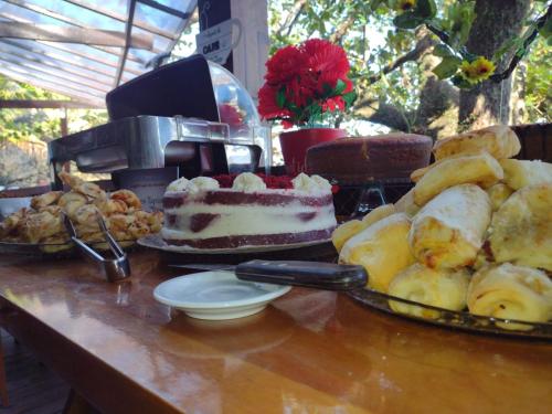 a table with a cake and various types of bread at Pousada Camarote Itaipu in Niterói