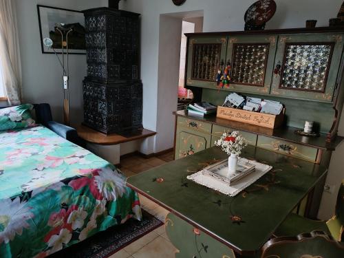 um quarto com uma cama e uma mesa com um vaso em Casa "Berto e Costantina" CIPAT 22253 em Tregiovo