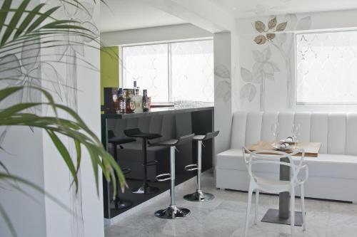 a kitchen with a bar with stools and a table at Arvo Hotel Boutique in Trujillo