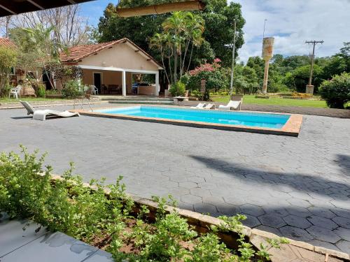 阿基道阿納的住宿－Pousada Cachoeira do Campo，一个带椅子的游泳池以及一座房子