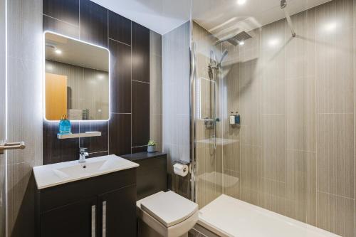 a bathroom with a toilet and a sink and a shower at Brimmond Homes - nr to Univ, Hospitals, o2 Apollo, PLAB & 7 mins to City Centre - Stylish, Modern & Secure 2 Bed, 2 Bath Apt with Allocated Free Parking in Manchester