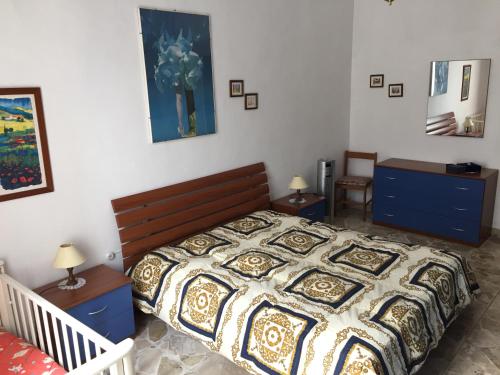 a bedroom with a bed with a quilt on it at Vittorio Emanuele apartment in Canicattini Bagni
