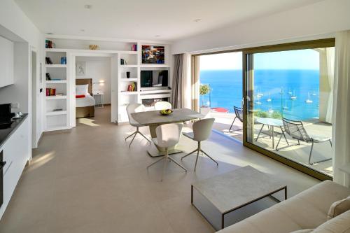 a living room with a table and a view of the ocean at LIVINGHOME SUITES in Parga