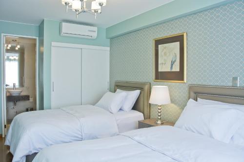 two beds in a room with blue walls at Arvo Hotel Boutique in Trujillo
