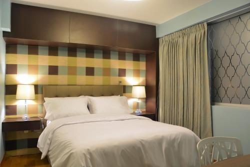 a bedroom with a large bed with two tables and two lamps at Arvo Hotel Boutique in Trujillo