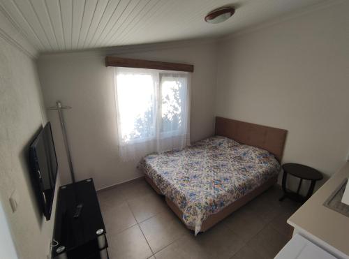a bedroom with a bed and a window at Villa Rain Cesme in Cesme