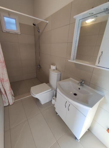 a white bathroom with a toilet and a sink at villa rain cesme in Çeşme