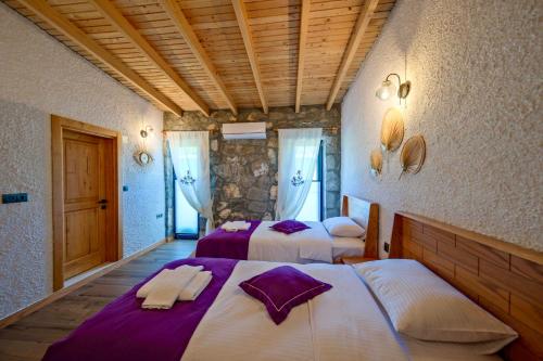 a bedroom with two beds with purple sheets at Villa Vareste & Villa Taş Mahal in Fethiye