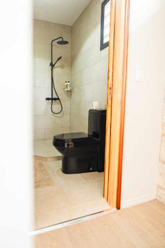 a bathroom with a shower and a black toilet at Le Village de Vairao in Vairao