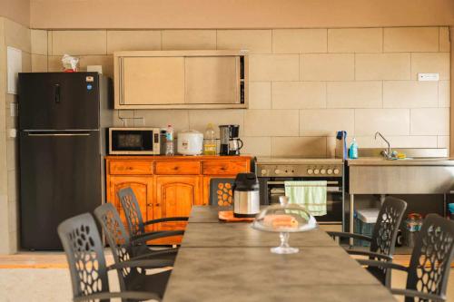 a kitchen with a table with chairs and a refrigerator at Le Village de Vairao in Vairao