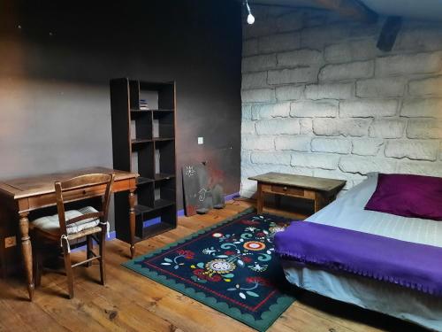 1 dormitorio con cama, escritorio y mesa en Chambres de charme chez l'habitant, en Baillargues