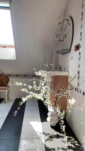 a bathroom with a vase with flowers on the floor at Dom z Widokiem w Rajgrodzie in Rajgród