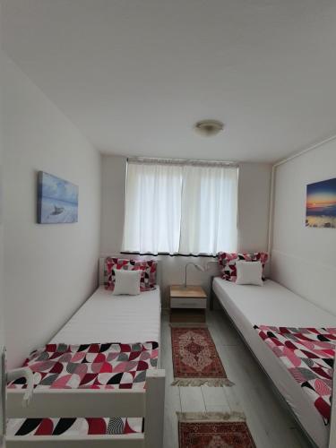 2 camas en una habitación con ventana en Studio apartment Sarajevo, en Sarajevo