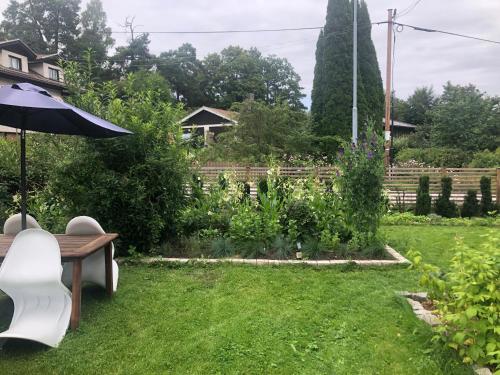 a garden with a bench and an umbrella at Private space with 2 bedrooms in Huddinge