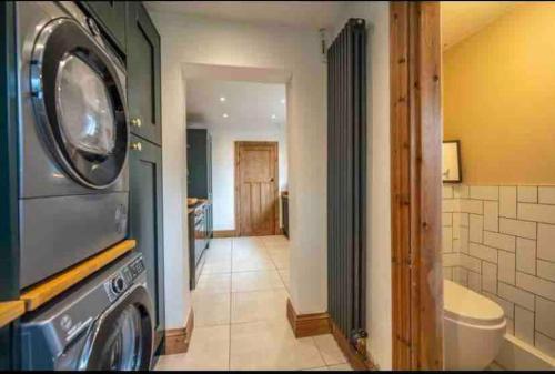 a bathroom with a washer and dryer in a room at Boho Beach House: Hot Tub in Cleethorpes