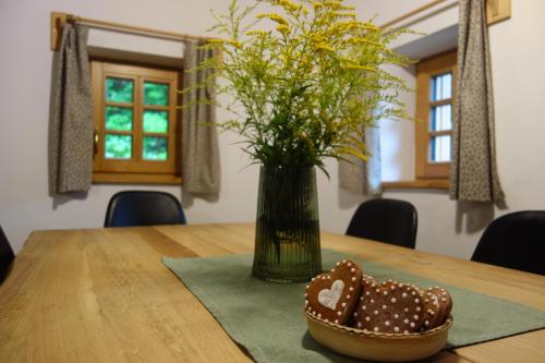 un tavolo con un vaso e una ciotola di fiori di Rábenka a Janov nad Nisou