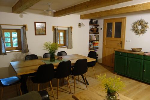 uma sala de jantar com uma mesa de madeira e cadeiras pretas em Rábenka em Janov nad Nisou