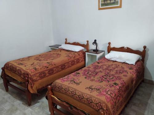 duas camas sentadas uma ao lado da outra num quarto em Hostal El Farolito em Humahuaca