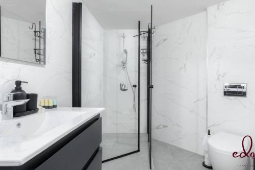 La salle de bains est pourvue d'une douche, d'un lavabo et de toilettes. dans l'établissement דירה במתחם עם בריכה 100 מטר מהים - By Edom, à Eilat