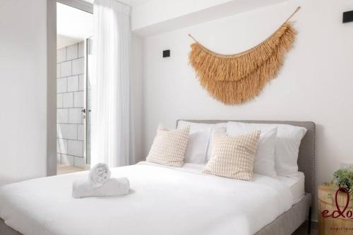 a white bedroom with a large white bed with pillows at דירה במתחם עם בריכה 100 מטר מהים - By Edomlux in Eilat