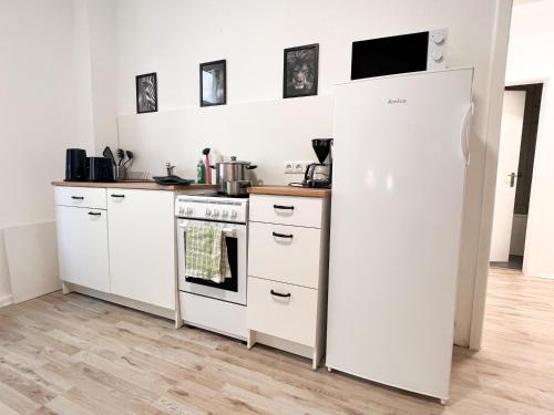 a kitchen with white cabinets and a refrigerator at 3 Zimmer mit 6 Betten, große Küche, neues Bad, 7min zur A1 in Hagen