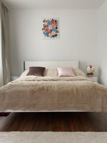 a white bedroom with a large bed with two pillows at Luxury Apart near Lake Bohinj in Bohinj