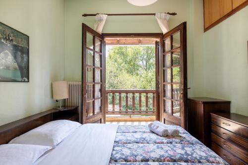 a bedroom with a bed and an open door at Zenios Dionysos - Traditional villa in Grevena