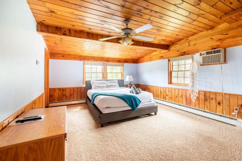 a bedroom with a bed and a ceiling fan at Bethel Woods Retreat - wPool, Hot Tub & Arcade! in Mongaup Valley