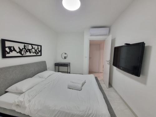 a bedroom with a bed and a flat screen tv at עלות השחר - יחידת אירוח בצפון in Qiryat Shemona