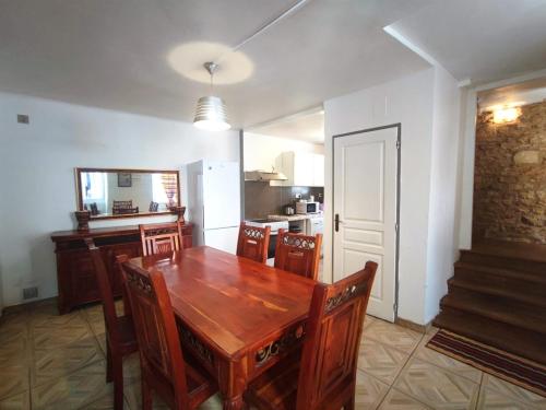 une cuisine et une salle à manger avec une table et des chaises en bois dans l'établissement Chez Baptiste, à Sarlat-la-Canéda