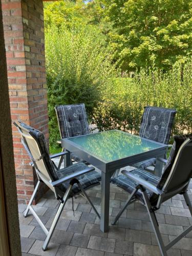 a glass table and chairs on a patio at Havelstern Ketzin, Ferienhaus Zander in Ketzin