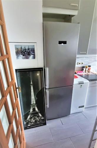 - un réfrigérateur dans la cuisine avec une photo de la tour Eiffel dans l'établissement Superbe chambre à clés Paris, à Sartrouville