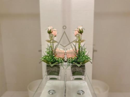 eine Vase voller rosa Rosen auf einem Waschbecken in der Unterkunft Minimalist Luxury Condo Classic Aesthetic at Azure in Manila